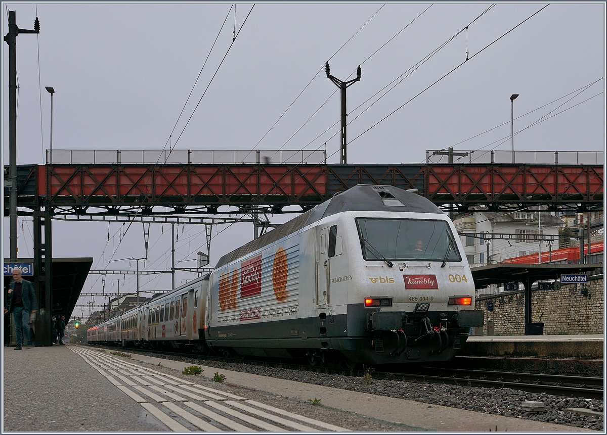 Die BLS Re 465 004-0 mit ihrem  Kambly -Zug auf der Fahrt nach La Chaux-de-Fonds beim Halt in Neuchâtel. 

29. Okt. 2019