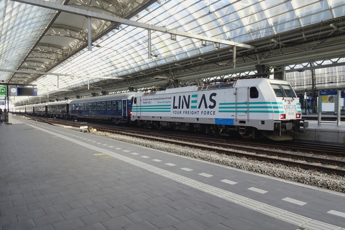 Leider in unsch�ne Lichtverh�ltnisse (Gegenlicht, Bahnsteighalle) aber doch: am 14 April 2022 steht Lineas 186 258 (mit ein Dankesch�n f�r das Sorgpersonal w�hrend der COVID_19 Krise) am Kops der VSOE nach Venezia Santa-Lucia in Amsterdam Centraal. Die 186 258 wird dieser Zug bis Schaerbeek schleppen, wo eine NMBS HLE18 die St�fe nach Aulnoye-Aymeries �bernimmt. Dort steht eine SYBIC Baureihe 26000 aufs Program und die Schleppt die (dann schlafende) Reisenden nach Lyon, wo die letzte St�fe mit wahrscheinlich eine Astride BB36300 volzogen werden soll.