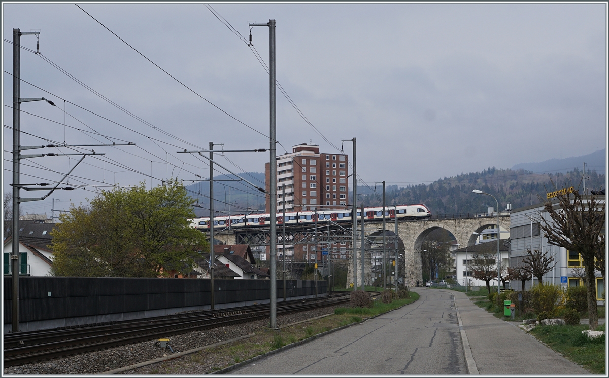 Während unten die Strecke von Biel/Bienne nach Olten verläuft, fährt im Hintergrund ein SBB RABe 522 als RE in Richtung Meroux TGV. Der Zug fährt über das Möösliviadukt und wird unmittelbar darauf seinen nächsten Halt Grenchen Nord erreichen. Die Strecke Lengnau - Grenchen Nord - Moutier gehört der BLS und firmt unter MLB.

18. April 2021