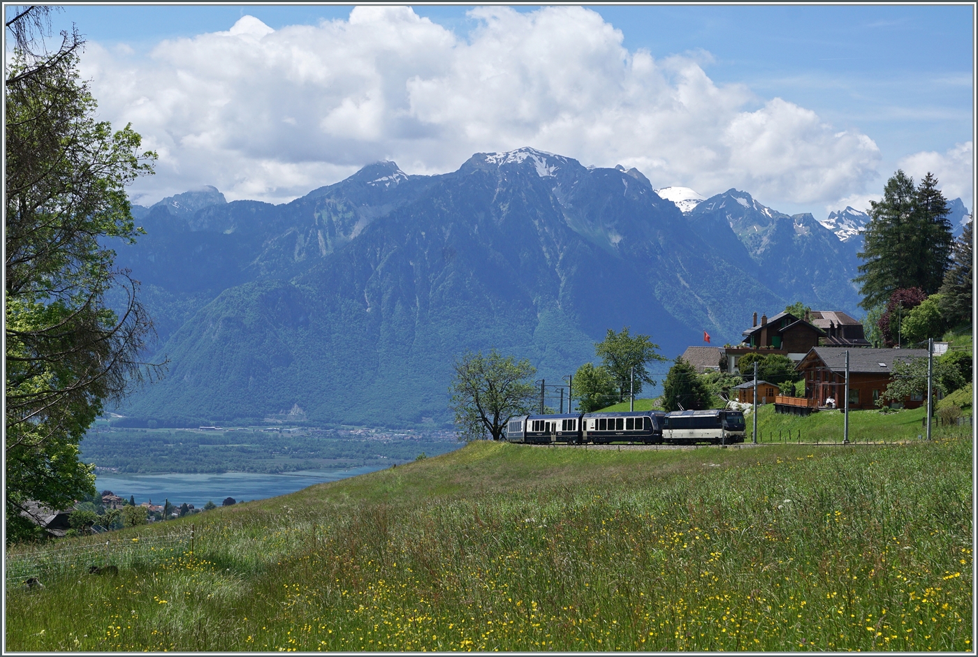 Die MOB Ge 4/4 8004 erreicht mit ihrem GoldenPass Express GPX 4074  Les Avants. Der Zug ist von Montreux nach Interlaken Ost unterwegs, in Zweisimmen wechselt der Zu die Lok und Spur. Neuerdings verkehrt der GPX fünfteilig, d.h. ein Niederflurwagen wurde nun in den Zugsverband eingesetzt. 

Das Bild zeit neben relativ wenig Zug um so mehr Landschaft, links im Bild ist sogar noch ein Zipfelchen des Genfer Sees zu sehen.

28. Mai 2024