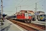 Die SBB Re 4/4 II mit einem BLS EW IV Reisezug auf der Fahrt nach Lausanne beim Halt in Neuchâtel.